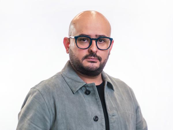 a person wearing glasses and a grey jacket
