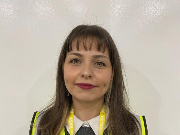 a person wearing a yellow vest and lanyard