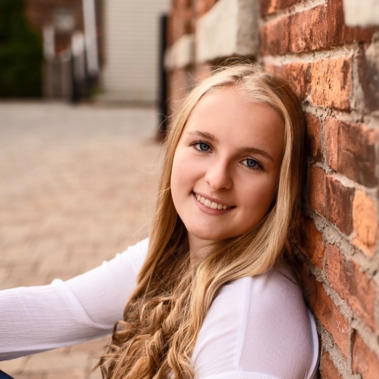 a person leaning against a brick wall