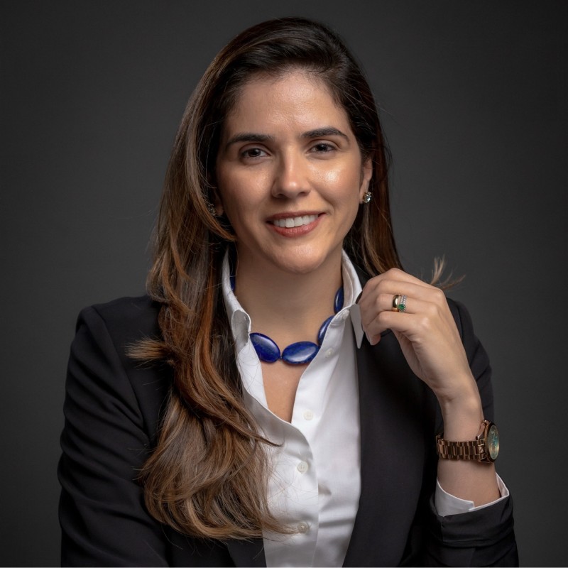 a person smiling with a blue necklace