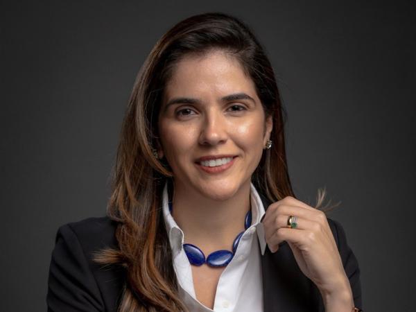 a person smiling with a blue necklace