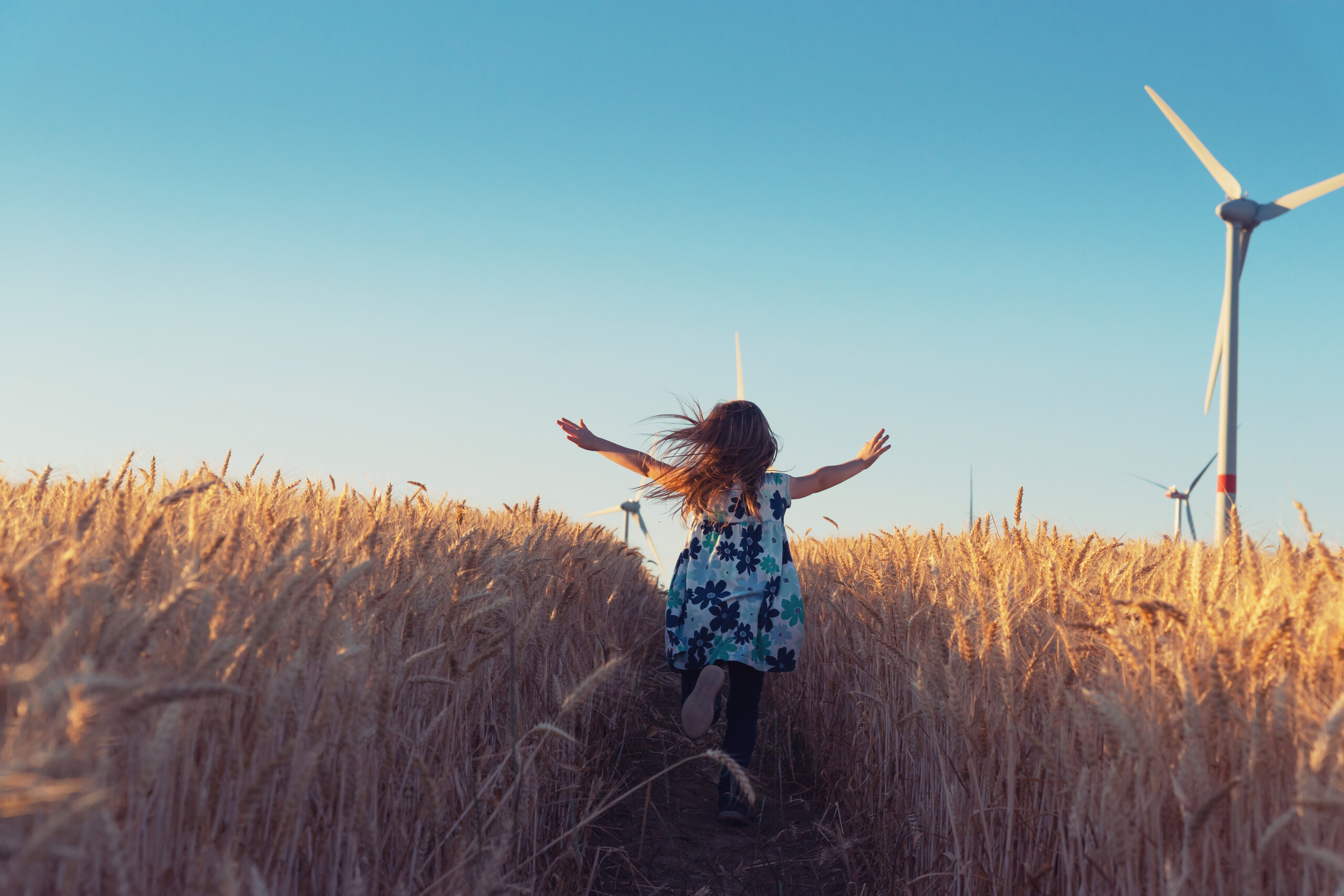 a child running through a field of wheat