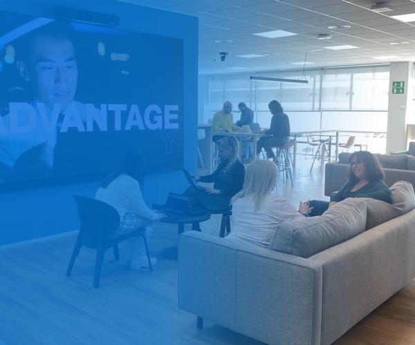 a group of people sitting in a room with a large screen