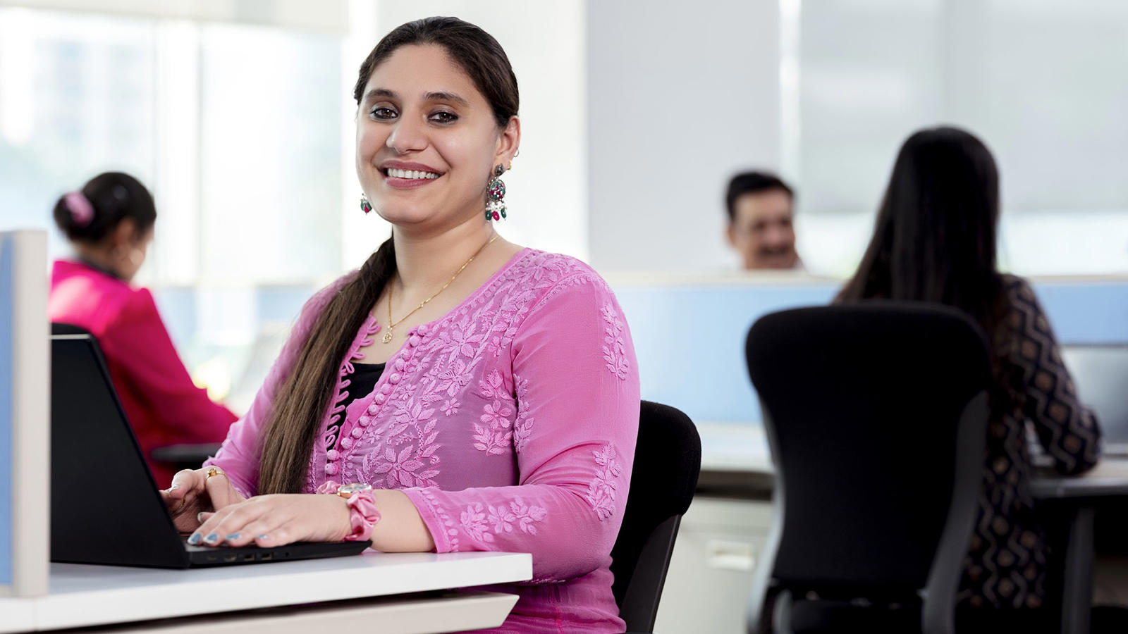 Female Associate Smiling Behind Laptop