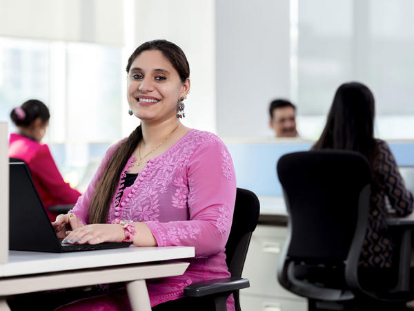 Female Associate Smiling Behind Laptop