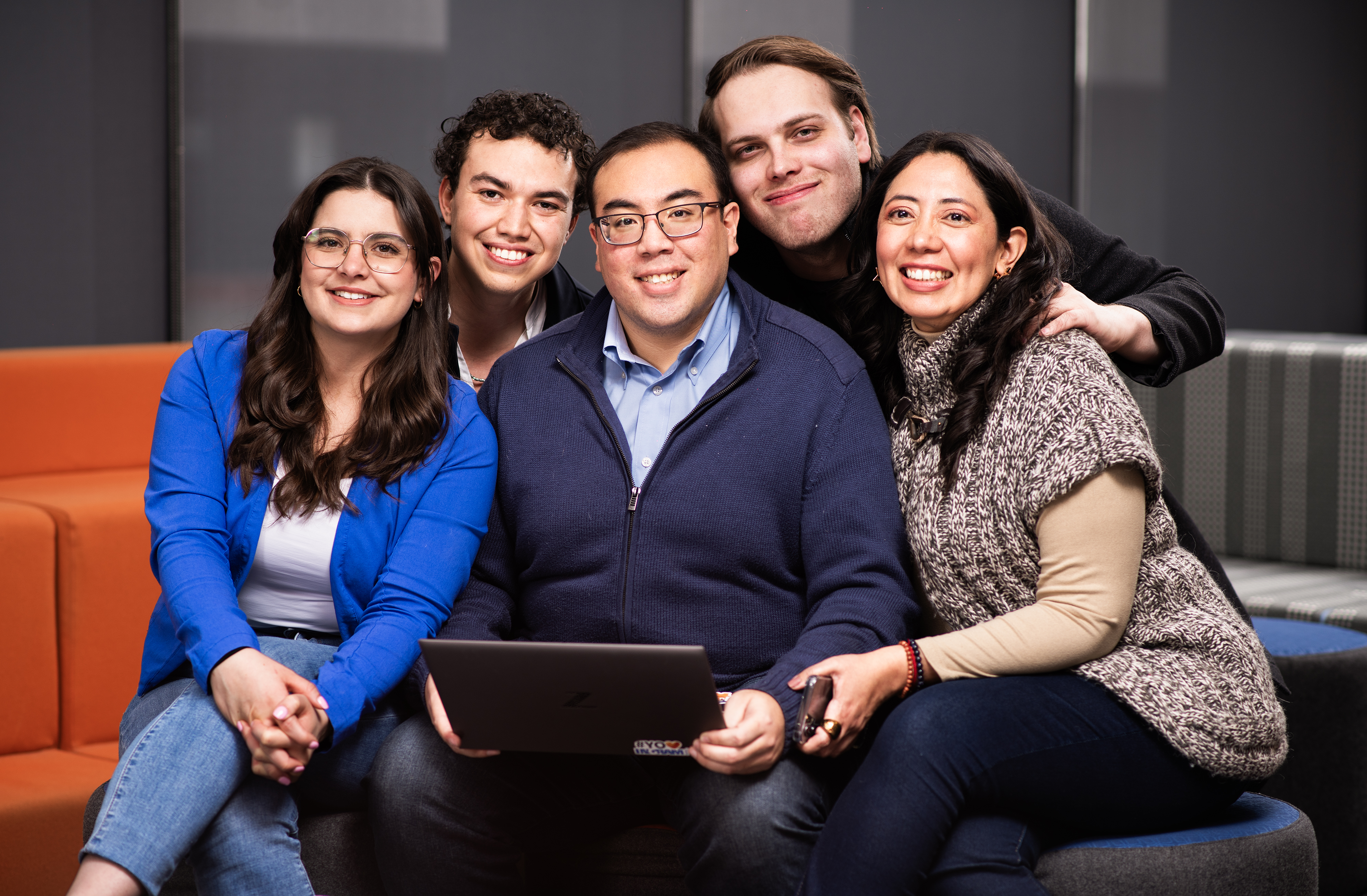 a group of people sitting on a couch smiling
