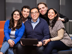 a group of people sitting on a couch smiling