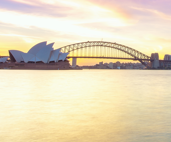 a body of water with a bridge and a city in the background
