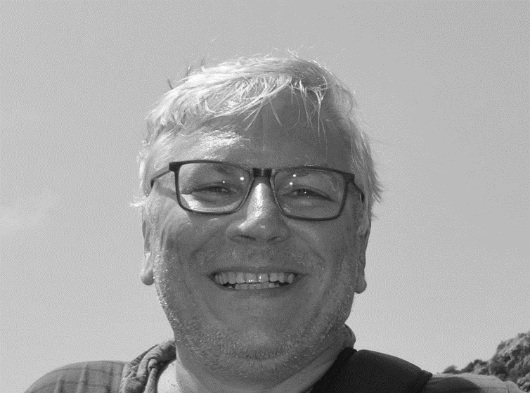 a person wearing glasses and smiling