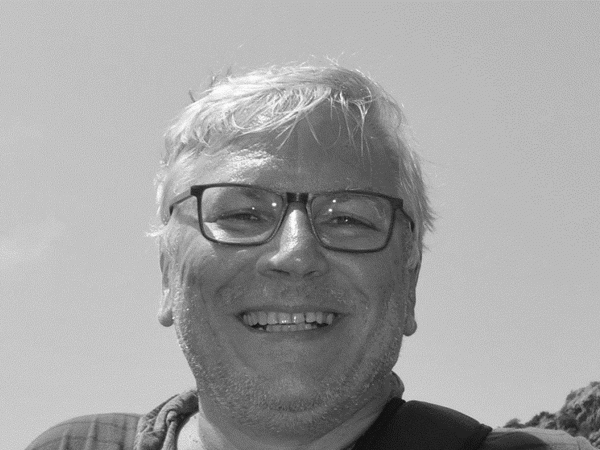 a person wearing glasses and smiling