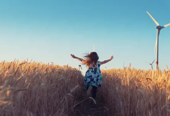 a child running through a field of wheat