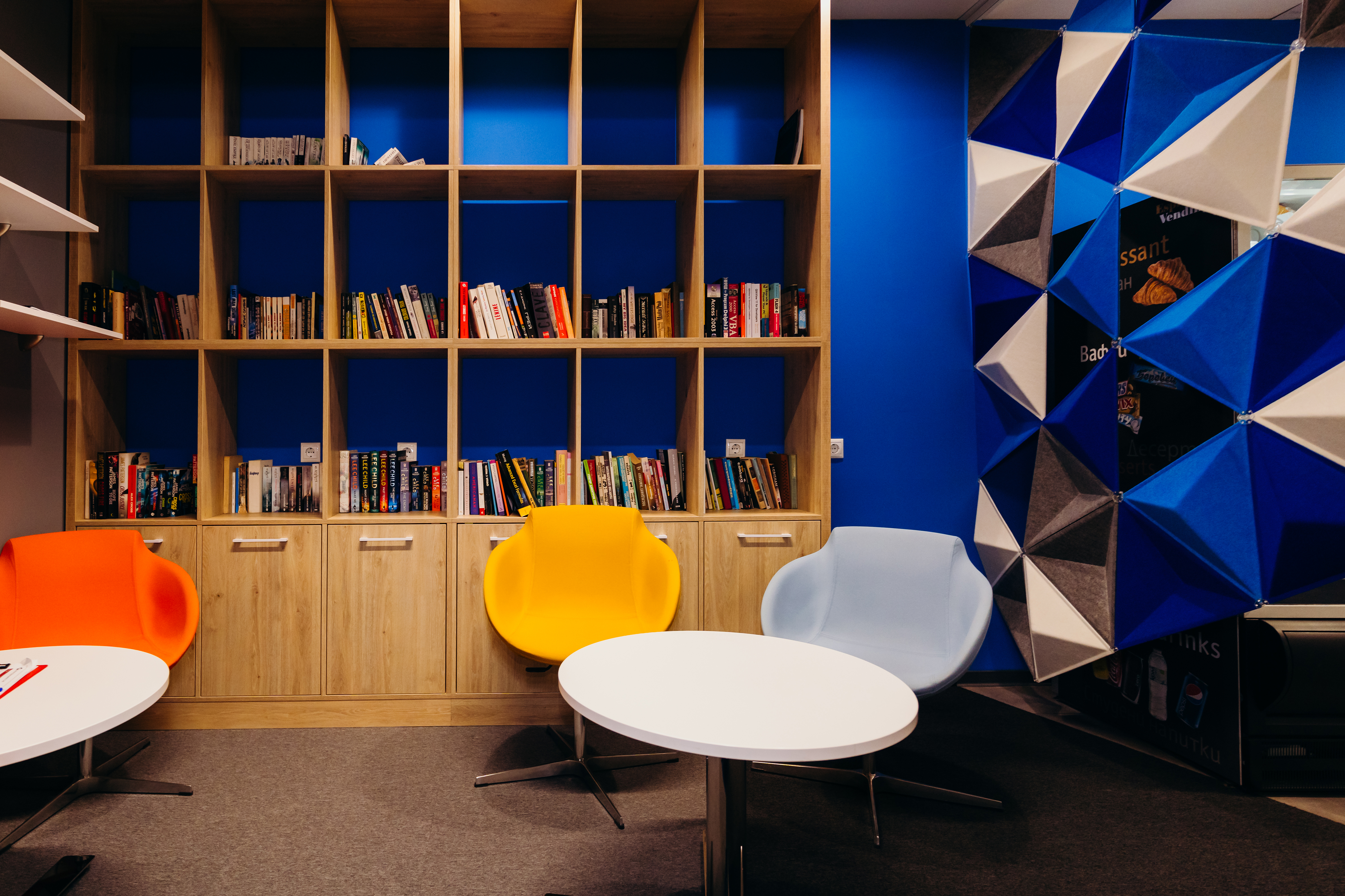 a room with a book shelf and chairs