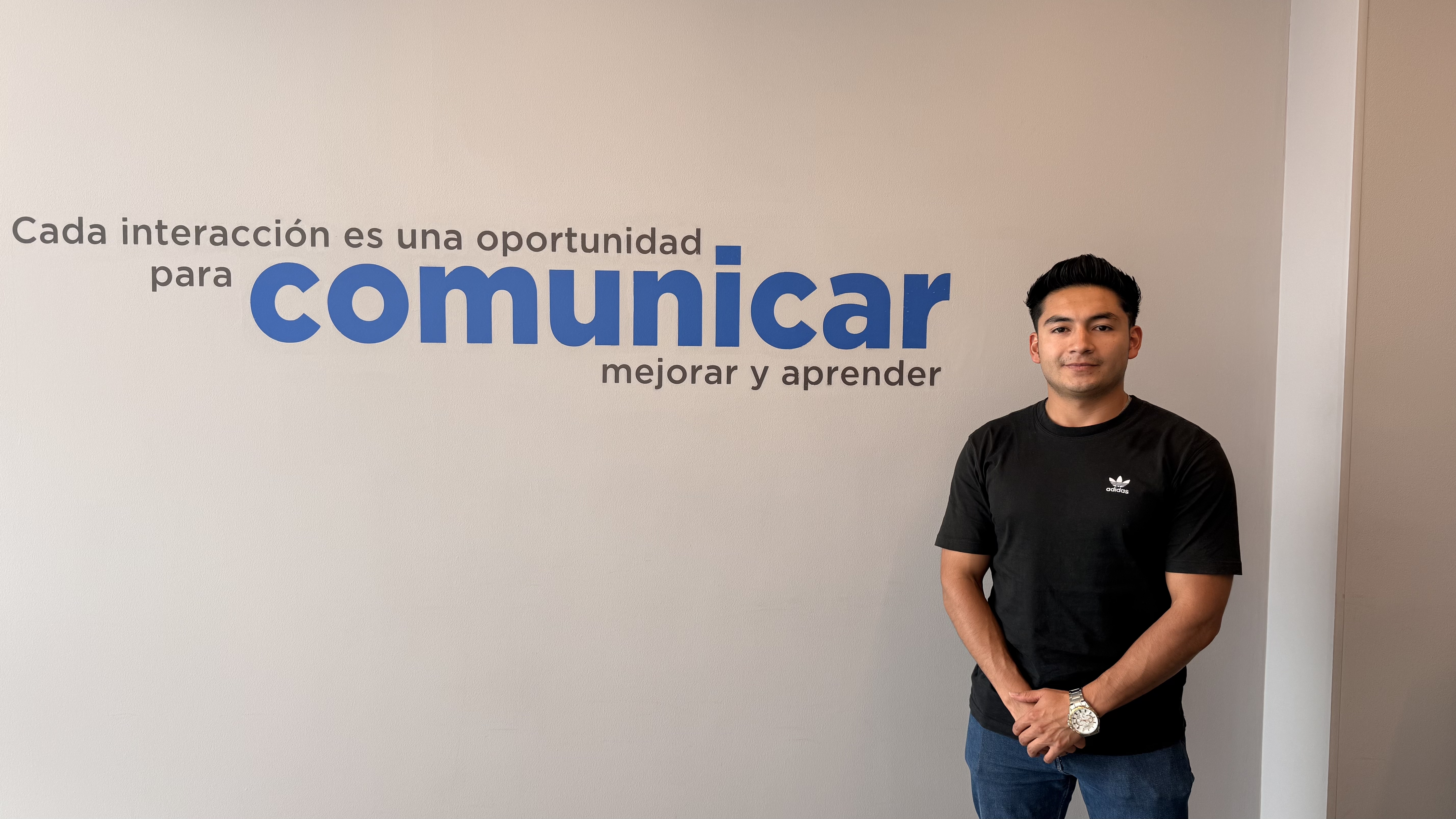 a person standing in front of a wall with blue text