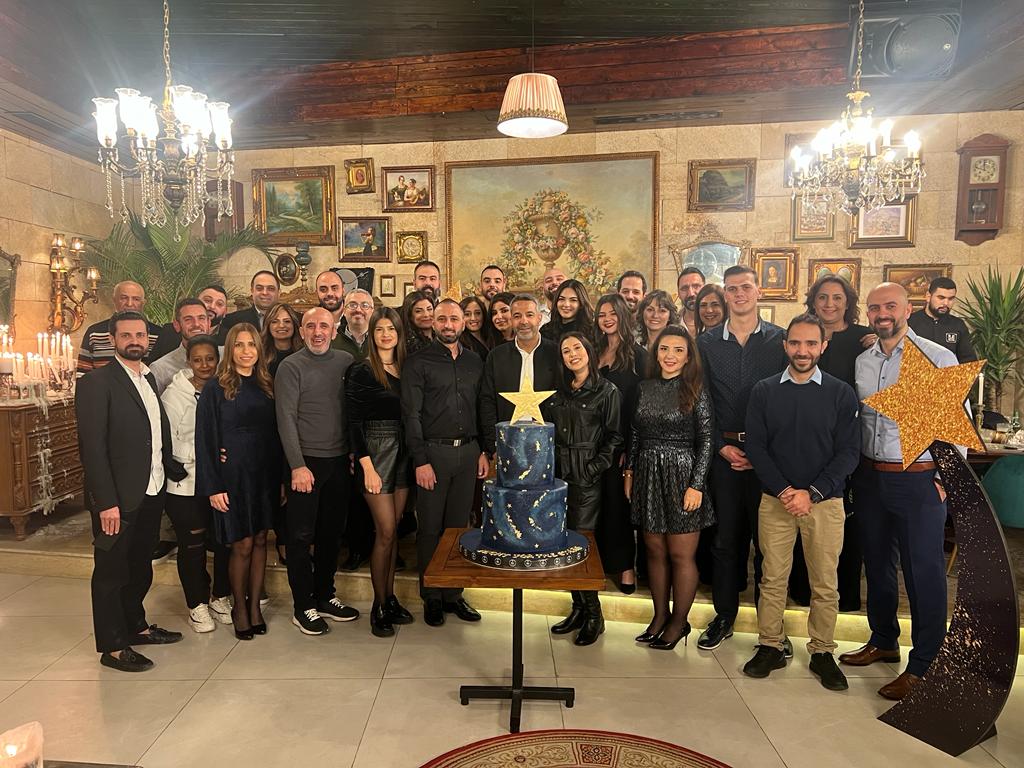 a group of people standing in front of a cake